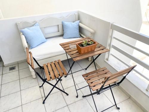 罗希姆诺Korona Beach Apartments I的小阳台配有长凳和桌椅。