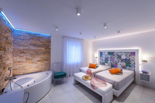 阿马尔菲Amalfi Suite Boutique Hotel的卧室配有床和浴缸,毗邻一个sidx sidx sidx床