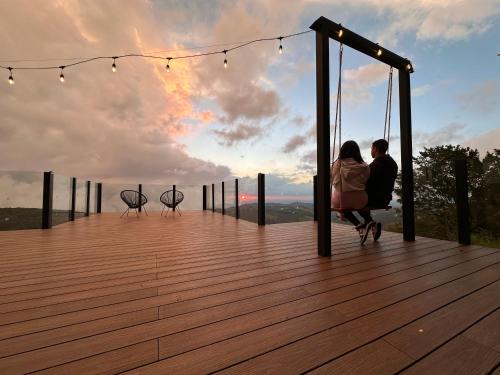 蒙泰韦尔德哥斯达黎加Amalú Monteverde的坐在甲板上的一对夫妇,欣赏日落