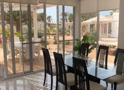 萨尔雷KatlantiK Villa Deluxe的一间设有玻璃桌和椅子的用餐室