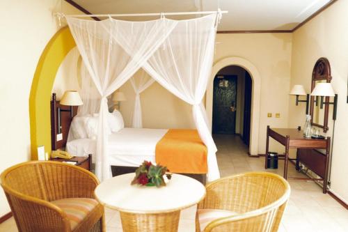维多利亚瀑布象山度假酒店的卧室配有一张床和一张桌子及椅子