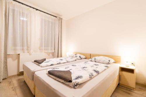 杜瑙保陶伊Szelidi Apartmanok的一间卧室设有两张床和窗户。