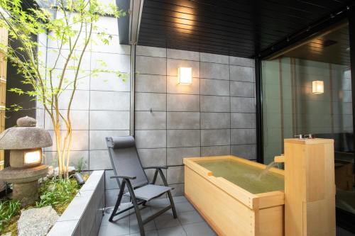 奈良奈良旅館別館 Sweet 螢 源的带浴缸和椅子的浴室