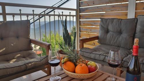 ‘Ein el AsadGardenia的一张桌子,上面放着一碗水果和两杯葡萄酒