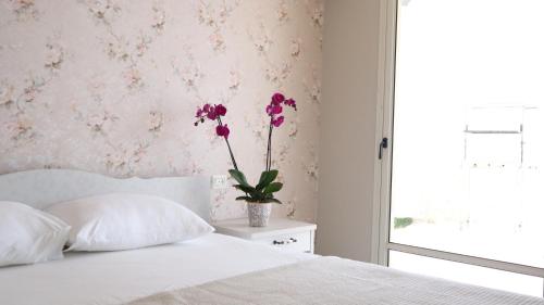 ‘Ein el AsadGardenia的一间卧室,配有一张带花瓶的床