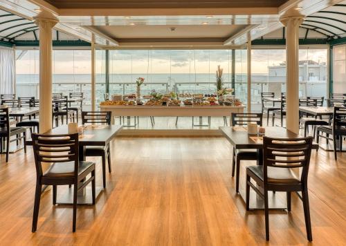 里米尼奥古斯都酒店的一间带桌椅的海景餐厅