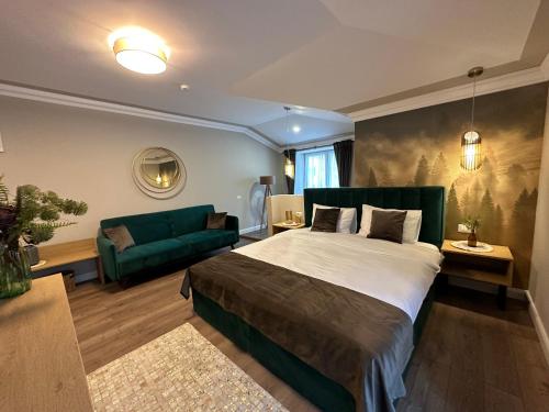 坎普朗莫道尼斯B59 BOUTIQUE HOTEL的一间卧室配有一张大床和一张绿色沙发