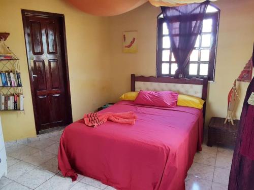 卡诺格布拉达VILLA com Wi-Fi, cozinha, parking, Canoa Quebrada zona centro, jardim tropical, tudu prossimo a pe的一间卧室配有一张带红色毯子的大床