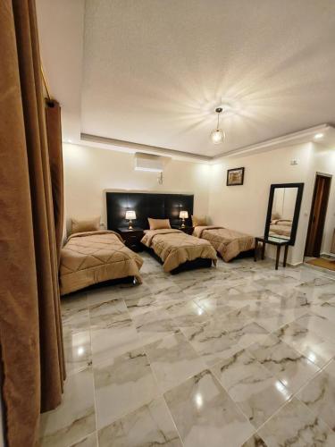 瓦迪穆萨iHome Petra的一间大型客房,设有两张床,铺有石地板