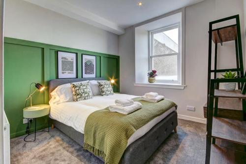 欧文The Irvine - Coorie Doon Apartments的一间卧室设有一张大床和一个窗户。
