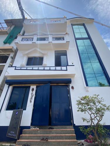 蓬蒂切里Casa De Neel的白色的建筑,设有蓝色的窗户和楼梯