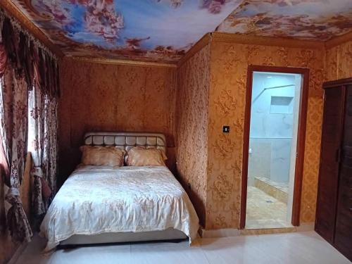 弗里敦Victorus Homes的一间卧室设有床铺和鲜花天花板