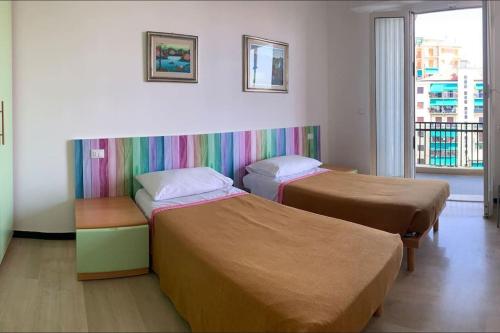 瓦拉泽Vista mare con ogni comfort的配有彩虹墙的客房内的两张床
