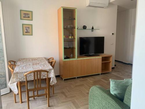 瓦拉泽Vista mare con ogni comfort的客厅配有桌子和平面电视。