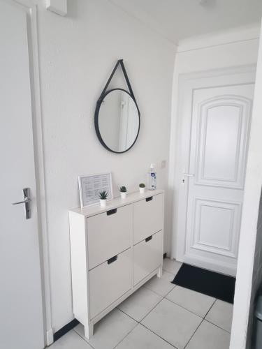勒宝洛Appartement coquet Le Boulou的白色的浴室设有镜子和白色梳妆台