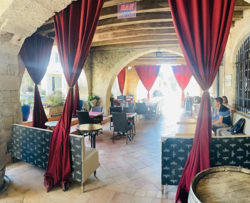 蒙特利尔Victorian Lodge的餐厅设有红色窗帘和桌椅