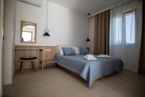 斯基罗斯岛Kotinos Luxury Suites的一间卧室配有蓝色的床和镜子