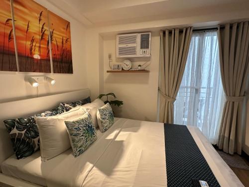 马尼拉Celandine Residence by DMCI的一间卧室设有一张大床和一个窗户。