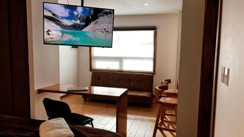 纳塔列斯港Origenes Apartments的客厅的墙上配有平面电视。