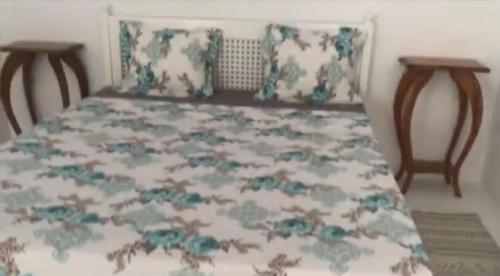哈马马特Dar Blanche的卧室内的一张床位,配有两把椅子和床罩