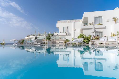 卡门港拉尼德豪华酒店 - 仅限成人的白色建筑前的游泳池