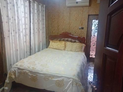 弗里敦Victorus Homes的一间卧室配有一张带白色床单的床和一扇窗户。