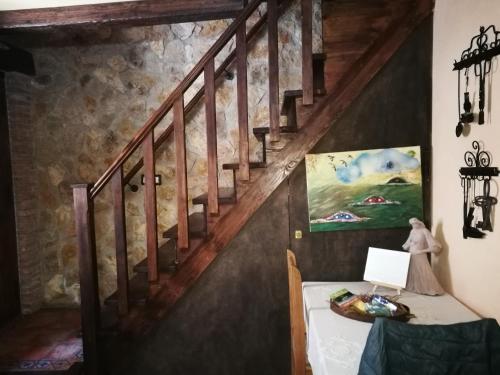 IznatorafCasa Rural Los Girasoles的楼梯,房间带桌子和绘画