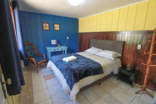 圣若泽杜斯皮尼艾斯Chácara do Sapé的卧室配有1张床、1张桌子和1把椅子