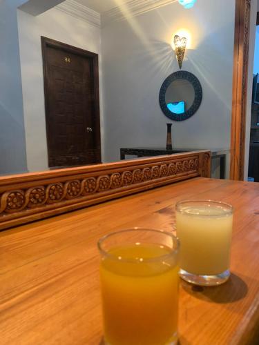 开罗Z Pyramids Inn的木桌旁的一杯橙汁