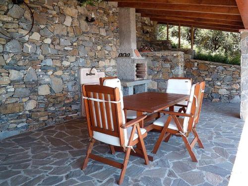 克里日亚La Casetta的一个带石墙的庭院里的一张木桌子和椅子