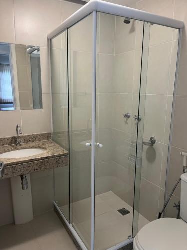 曼加拉蒂巴Apartamento Rio Marina Resort的玻璃淋浴间设有水槽和卫生间