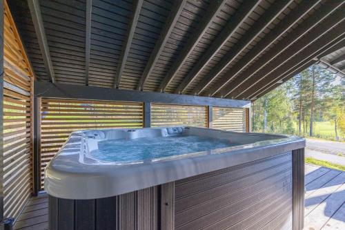 耶姆赛Luksushuvila Villa Marvik的木制建筑中的一个大型热水浴缸