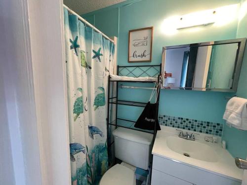 格尔夫海岸Gulf Shores Getaway steps away from the pool!的一间带卫生间、水槽和镜子的浴室