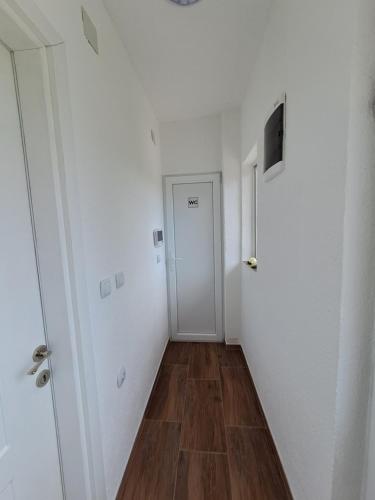 诺弗多伊兰Lazarov Apartments的一条空的走廊,有门,有木地板