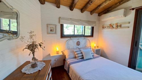 德尔迪阿布罗角Cabañas Bahia Serena的一间卧室配有一张床、一张桌子和两个窗户