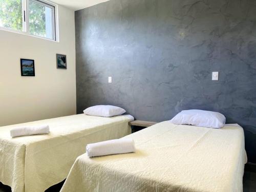 塔马林多Condominios Akira的一间设有两张带白色床单的床的房间