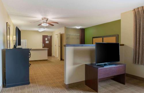 罗缪勒斯底特律大都会机场长住酒店的一间带电视的客厅和一间客厅。