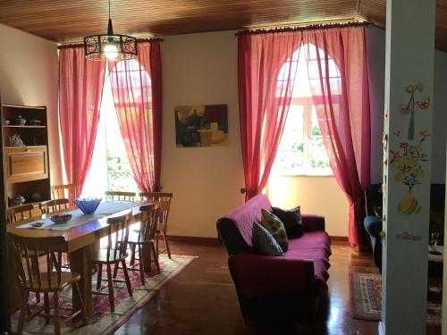 戈韦阿Casa das Camélias的客厅设有餐桌和红色窗帘
