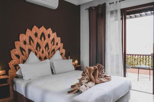 马拉喀什Magnifiaue appart的一间卧室配有一张大床和木制床头板