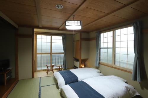 野沢内田屋旅馆的一间卧室设有两张床和两个大窗户
