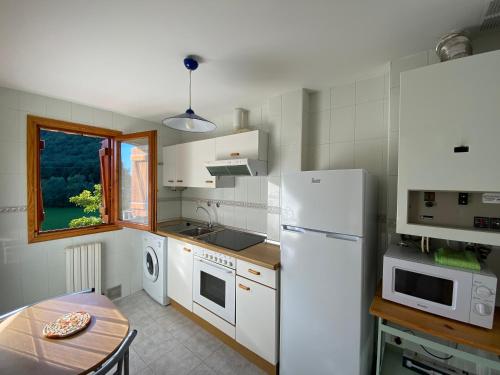 毕斯卡斯BUENAVISTA2的厨房配有桌子和白色冰箱。