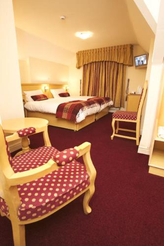 纽波特盖特威酒店的酒店客房,配有两张床和两把椅子