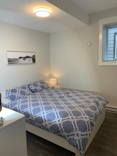 纳奈莫Modern 2BR Guest House in North Nanaimo的一间卧室配有一张带蓝色棉被的床