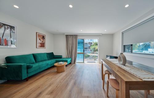 黄金海岸Red Star Palm Beach的客厅配有绿色沙发和桌子