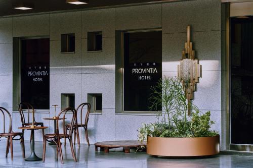 台南天下南隅 Provintia Hotel的一间设有桌椅和盆栽的餐厅