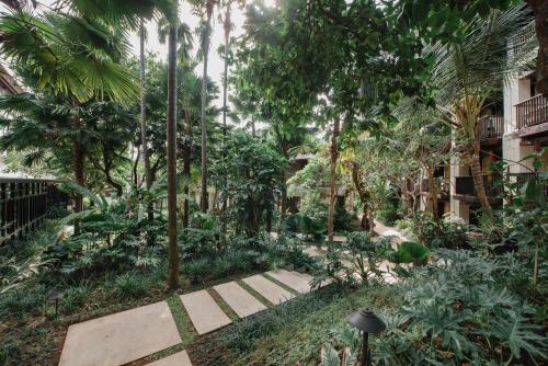 库塔Ramayana Suites and Resort的种有棕榈树和步道的花园
