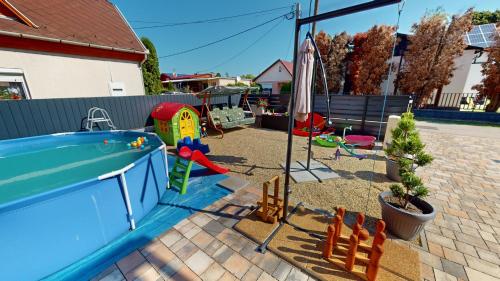 迈泽克韦什德Silver Zsóry Apartman的后院设有带游泳池和玩具的游乐场