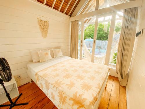 吉利特拉旺安Love Coconut Bungalow的一间带床的卧室,位于带窗户的房间内