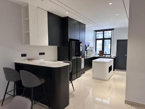 太平Luxe J Homestay的厨房配有黑白橱柜和柜台。
