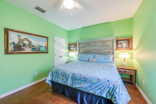 阿兰瑟斯港Pirates Bay #118 The LUV Shack poolfront townhome的一间卧室设有绿色的墙壁和一张带木制床头板的床